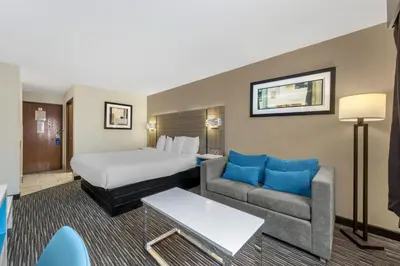 a hotel room with a bed and a couch at Best Western Columbus Airport in Columbus