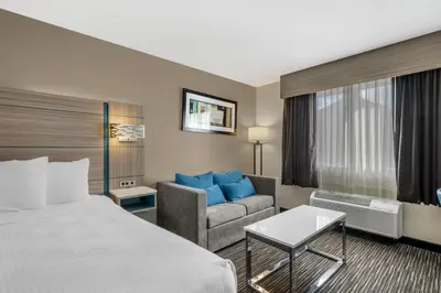 a hotel room with a bed and a couch at Best Western Columbus Airport in Columbus