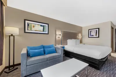a hotel room with a bed and a couch at Best Western Columbus Airport in Columbus