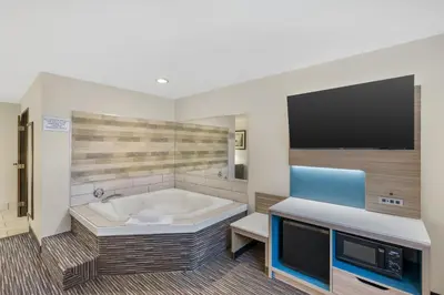 a large bathroom with a tub and a tv at Best Western Columbus Airport in Columbus