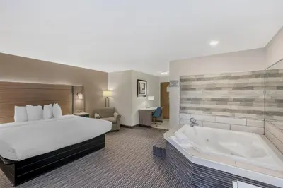 a hotel room with a bed and a bath tub at Best Western Columbus Airport in Columbus