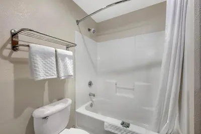 a white bathroom with a toilet and a bath tub at Best Western Columbus Airport in Columbus