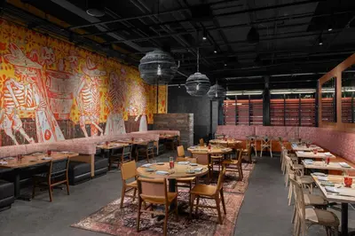 a restaurant with wooden tables and chairs and a mural at The Westin Cleveland Downtown in Cleveland