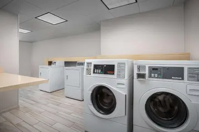 a laundry room with two washing machines and a counter at Homewood Suites by Hilton Cleveland-Solon in Solon