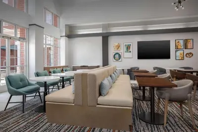 a waiting room with a couch and tables and a tv at Homewood Suites by Hilton Cleveland-Solon in Solon