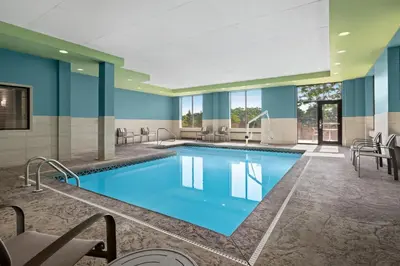 a pool in the lobby of a hotel with blue walls at Holiday Inn Express Hotel and Suites Akron South-Airport Area by IHG in Akron