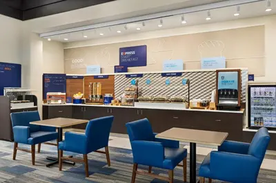 a coffee shop with blue chairs and tables and a counter at Holiday Inn Express Hotel and Suites Akron South-Airport Area by IHG in Akron