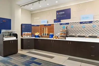 a bakery with a counter with food on it at Holiday Inn Express Hotel and Suites Akron South-Airport Area by IHG in Akron