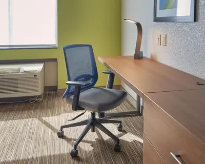 a blue office chair sitting in front of a desk at Holiday Inn Express Hotel and Suites Akron South-Airport Area by IHG in Akron