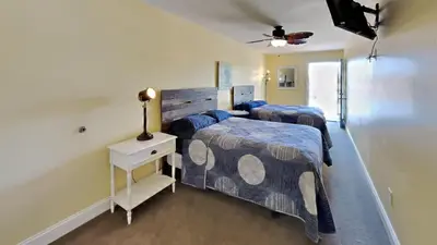 a bedroom with two beds and a table with a lamp at Put-in-Bay Waterfront Condo #205 in Put-in-Bay