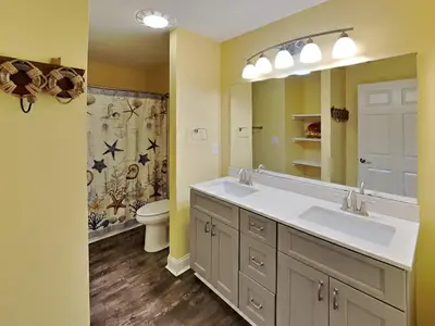 a bathroom with two sinks and a toilet and a mirror at Put-in-Bay Waterfront Condo #211 in Put-in-Bay