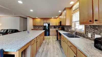 a kitchen with wooden cabinets and a black refrigerator at Put-in-Bay Island Club #111 in Put-in-Bay