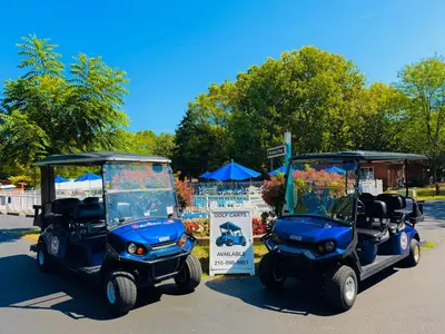 two golf carts are parked next to a sign at Put-in-Bay Island Club #77 in Put-in-Bay