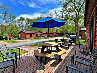 a picnic table with a blue umbrella and benches at Put-in-Bay Island Club #77 in Put-in-Bay