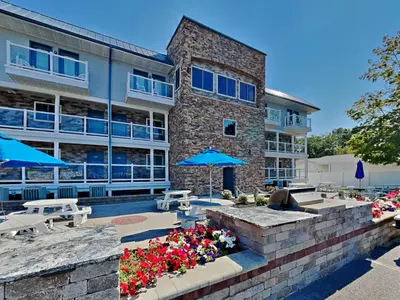 a building with blue umbrellas and flowers in front of it at Put-in-Bay Waterfront Condo #105 in Put-in-Bay