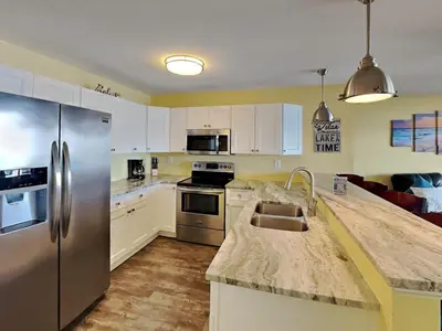 a kitchen with stainless steel appliances and white cabinets at Put-in-Bay Waterfront Condo #105 in Put-in-Bay