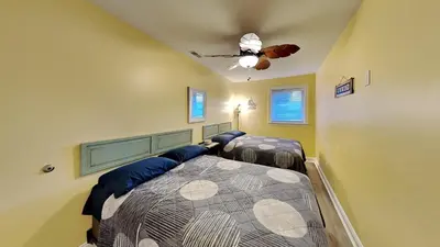 a bedroom with two beds and a ceiling fan at Put-in-Bay Waterfront Condo #106 in Put-in-Bay