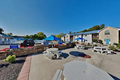 a patio with tables and chairs and blue umbrellas at Put-in-Bay Waterfront Condo #106 in Put-in-Bay