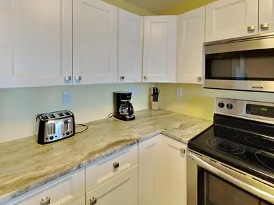 a kitchen with white cabinets and a toaster on the counter at Put-in-Bay Waterfront Condo #111 in Put-in-Bay