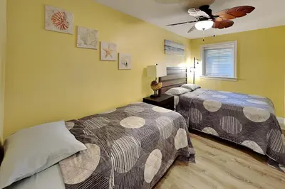 a bedroom with two beds and a ceiling fan at Put-in-Bay Waterfront Condo #111 in Put-in-Bay