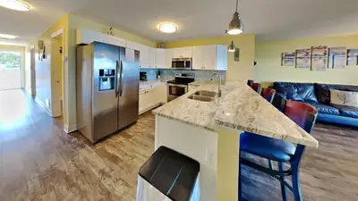 a kitchen and living room with a counter and a refrigerator at Put-in-Bay Waterfront Condo #107 in Put-in-Bay
