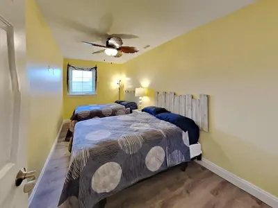 a bedroom with two beds and a ceiling fan at Put-in-Bay Waterfront Condo #107 in Put-in-Bay