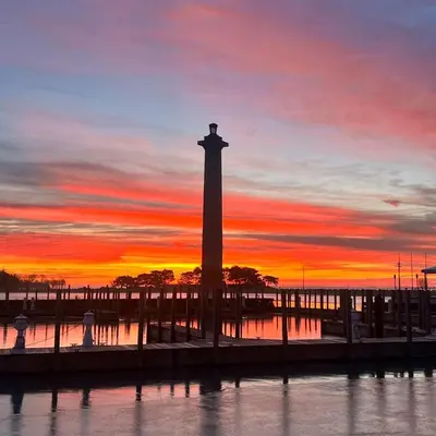 a lighthouse in the water with a sunset in the background at Put-in-Bay Waterfront Condo #107 in Put-in-Bay