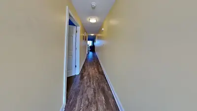 an empty corridor in a house with white walls and wood floors at Put-in-Bay Waterfront Condo #107 in Put-in-Bay