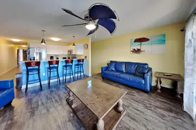 a living room with a blue couch and a table at Put-in-Bay Waterfront Condo #109 in Put-in-Bay