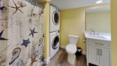 a bathroom with a washing machine and a sink at Put-in-Bay Waterfront Condo #109 in Put-in-Bay