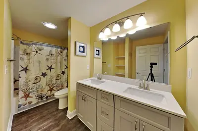 a bathroom with a sink and a toilet and a mirror at Put-in-Bay Waterfront Condo #109 in Put-in-Bay