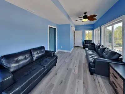 a living room with black leather couches and blue walls at Put-in-Bay Waterfront Condo #208 in Put-in-Bay