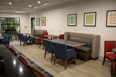 a waiting room at a restaurant with tables and chairs at Holiday Inn Express Hotel & Suites Athens by IHG in Athens