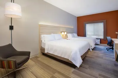 a hotel room with two beds and a chair at Holiday Inn Express Hotel & Suites Athens by IHG in Athens