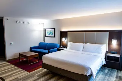 a hotel room with a bed and a blue chair at Holiday Inn Express - Columbus - Dublin by IHG in Dublin