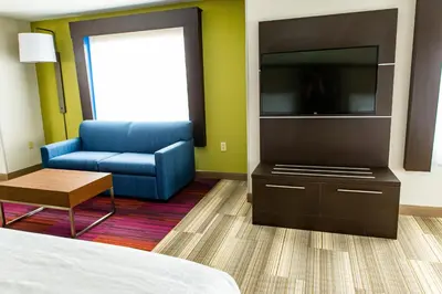 a room with a bed and a tv and a chair at Holiday Inn Express - Columbus - Dublin by IHG in Dublin