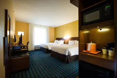 a hotel room with two beds and a flat screen tv at Fairfield by Marriott Cambridge in Cambridge