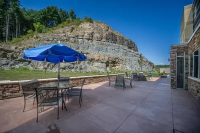 a table and chairs with an umbrella on a patio at Fairfield by Marriott Cambridge in Cambridge