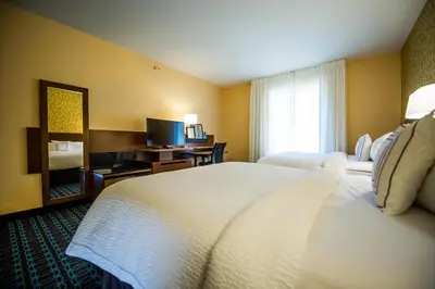 a hotel room with a large bed and a television at Fairfield by Marriott Cambridge in Cambridge