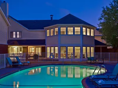 a house with a swimming pool in front of a house at Sonesta Simply Suites Cleveland Airport in Middleburg Heights