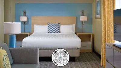 a hotel room with a bed and a chair at Sonesta Simply Suites Cleveland Airport in Middleburg Heights