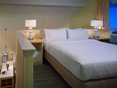 a hotel room with a bed and two night stands at Sonesta Simply Suites Cleveland Airport in Middleburg Heights