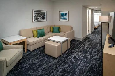 a living room with a couch and a table at Delta Hotels by Marriott Huntington Downtown in Huntington