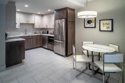 a kitchen with a table and a refrigerator at Delta Hotels by Marriott Huntington Downtown in Huntington