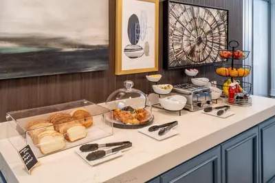 a breakfast buffet with bread and pastries on a counter at Delta Hotels by Marriott Huntington Downtown in Huntington