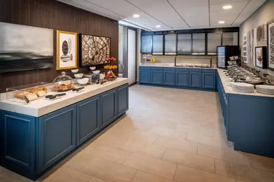 a large kitchen with blue cabinets and a counter top at Delta Hotels by Marriott Huntington Downtown in Huntington