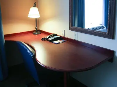a table in a room with a lamp and a mirror at Hampton Inn Morehead in Morehead
