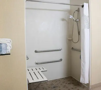 a bathroom with a shower door in a room at Hampton Inn Morehead in Morehead