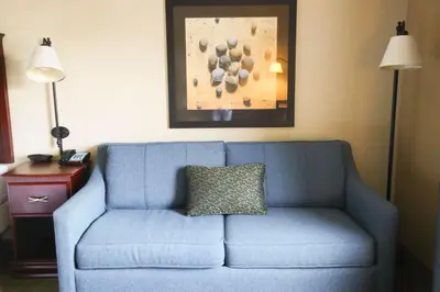 a blue couch in a hotel room with a pillow on it at Hampton Inn Morehead in Morehead