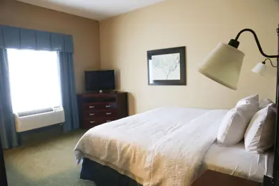 a bedroom with a white bed and a television at Hampton Inn Morehead in Morehead